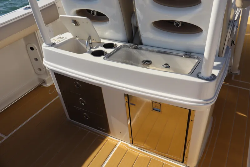 Slide: The Image of 2017 Sailfish 320 CC boat interior with sink, storage drawers, and stainless steel features. - 19