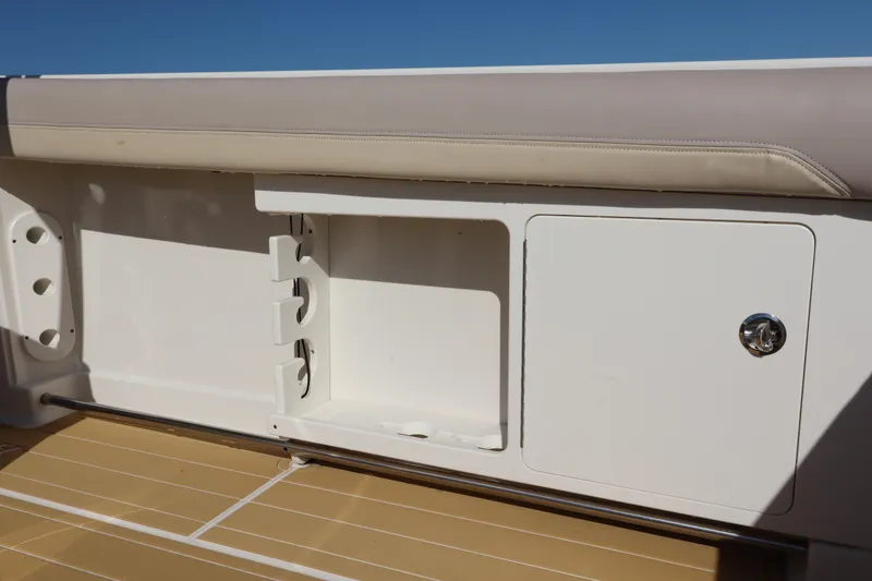 Slide: The Image of 2017 Sailfish 320 CC boat storage compartment with beige cushioned seating. - 23