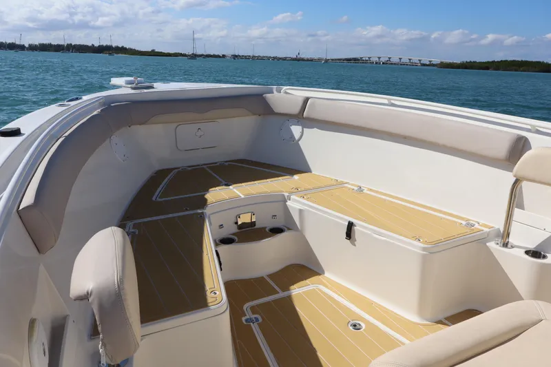 Slide: The Image of 2017 Sailfish 320 CC boat interior with cushioned seating and ocean view. - 8