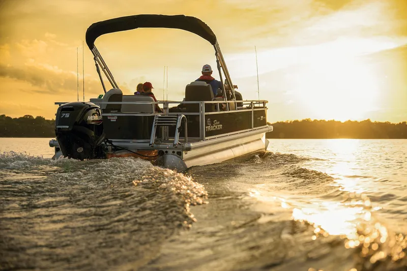 Slide: The Image of Manufacturer Provided Image: 2026 Sun Tracker Bass Buggy 18 DLX pontoon boat cruising at sunset on a serene lake. - 88