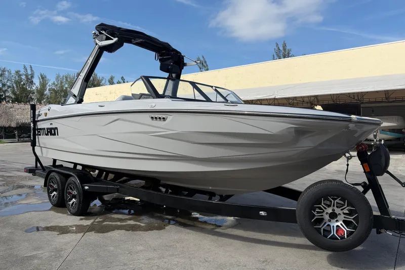 The Image of 2026 Centurion Nv233 boat on trailer, sleek design, parked outdoors. - 1