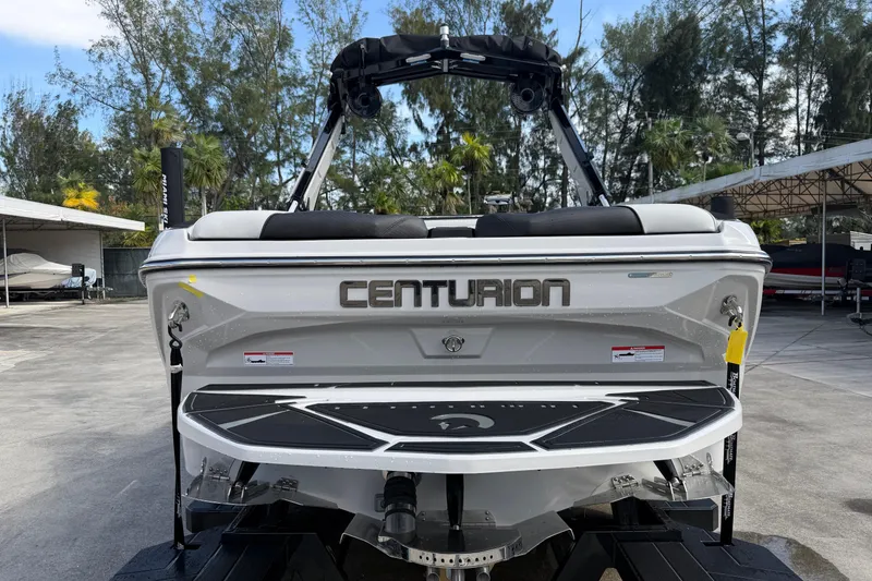 Slide: The Image of 2026 Centurion Nv233 boat rear view in a marina setting. - 6