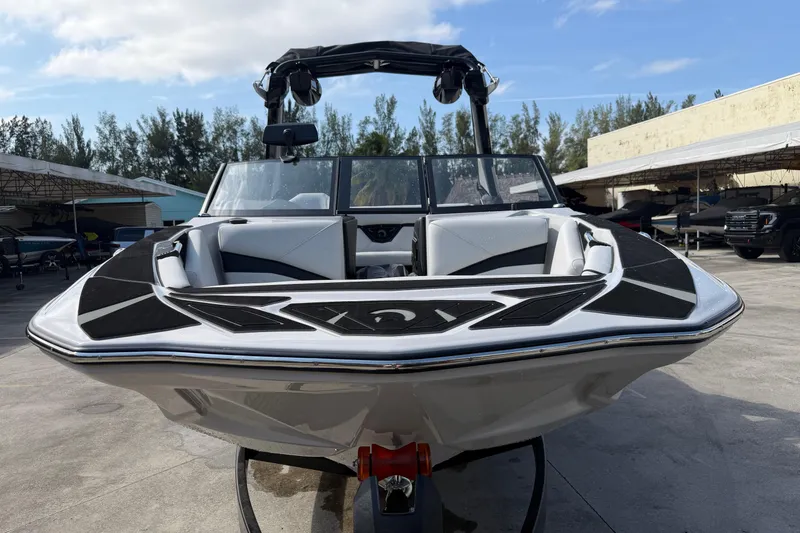 Slide: The Image of 2026 Centurion Nv233 boat with sleek design, parked outdoors on a sunny day. - 7