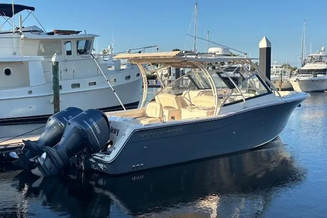 Slide: The Image of 2016 Grady-White Freedom 307 boat docked in marina with twin outboard engines. - 1