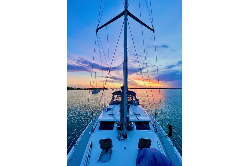 Slide: The Image of Hunter 426 Deck Salon 2003 sailboat at sunset on calm waters. - 1