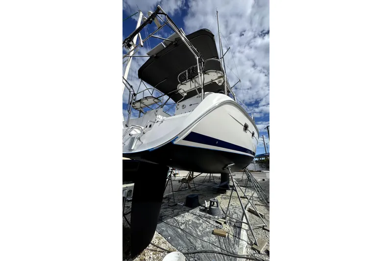 Slide: The Image of 2003 Hunter 426 Deck Salon sailboat on dry dock under a cloudy sky. - 100