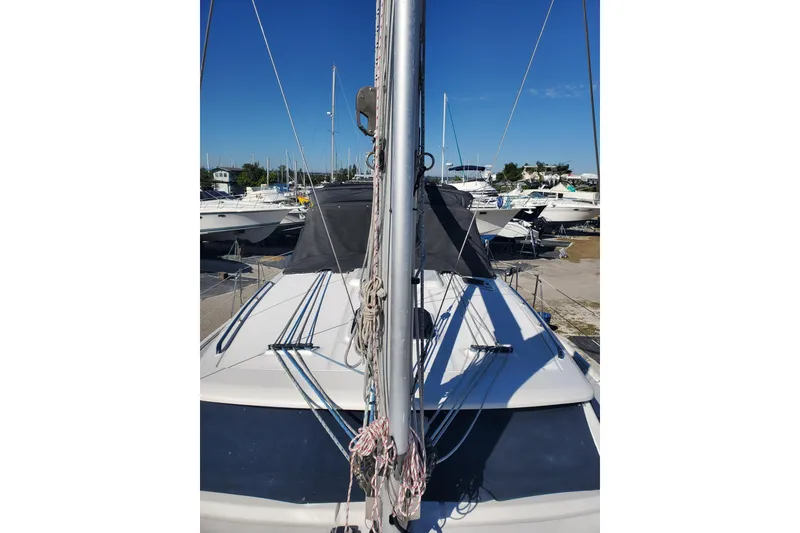 Slide: The Image of 2003 Hunter 426 Deck Salon sailboat docked, showcasing mast and deck details. - 13