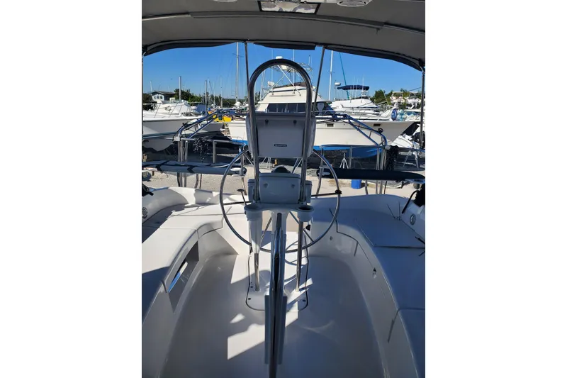 Slide: The Image of 2003 Hunter 426 Deck Salon cockpit with steering wheel, docked in marina. - 22