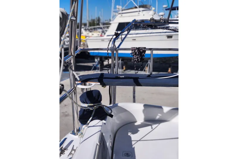 Slide: The Image of Hunter 426 Deck Salon 2003 sailboat with marina background, featuring polished metal railings. - 37