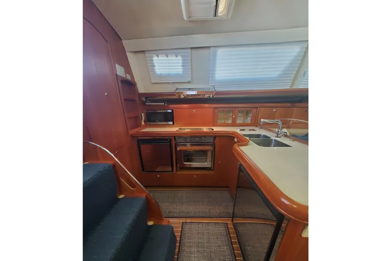 Slide: The Image of Interior of 2003 Hunter 426 Deck Salon yacht kitchen with wood cabinetry and modern appliances. - 45