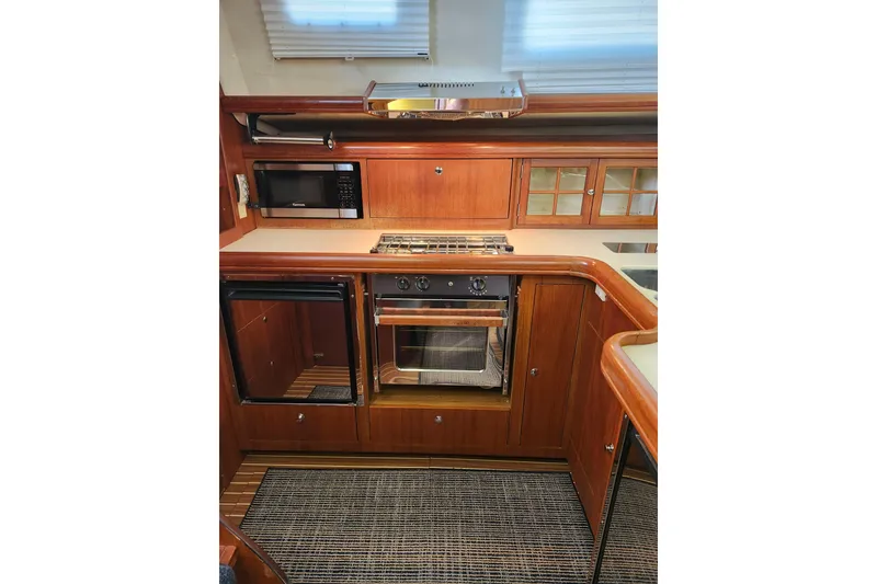 Slide: The Image of Kitchen area of 2003 Hunter 426 Deck Salon with wood cabinetry and modern appliances. - 46