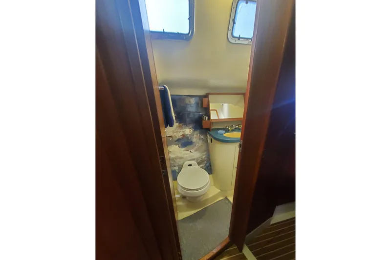 Slide: The Image of Bathroom interior of 2003 Hunter 426 Deck Salon yacht, featuring toilet and sink. - 65