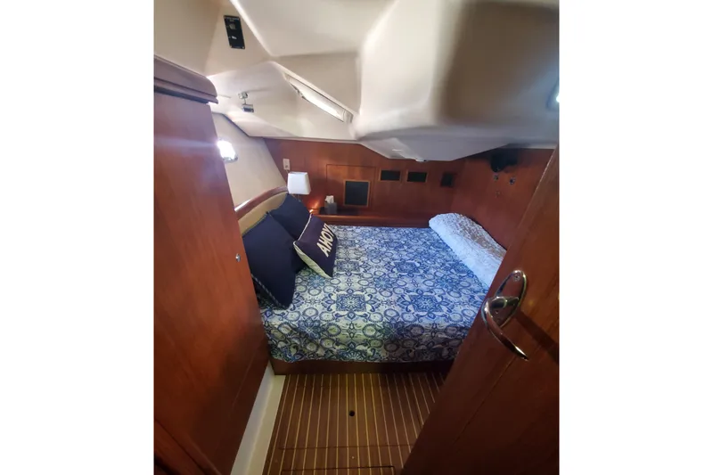 Slide: The Image of Cozy cabin interior of 2003 Hunter 426 Deck Salon with patterned bedding and wooden accents. - 71