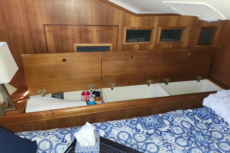 Slide: The Image of Interior storage of 2003 Hunter 426 Deck Salon yacht with wooden panels and bedding. - 74