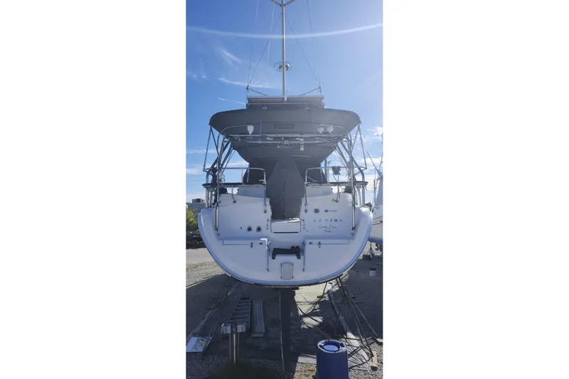 Slide: The Image of 2003 Hunter 426 Deck Salon sailboat on land, rear view under clear sky. - 8