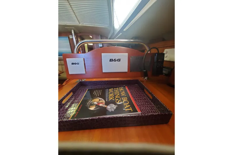 Slide: The Image of Interior of 2003 Hunter 426 Deck Salon with B&G equipment and a book on boat mechanics. - 81