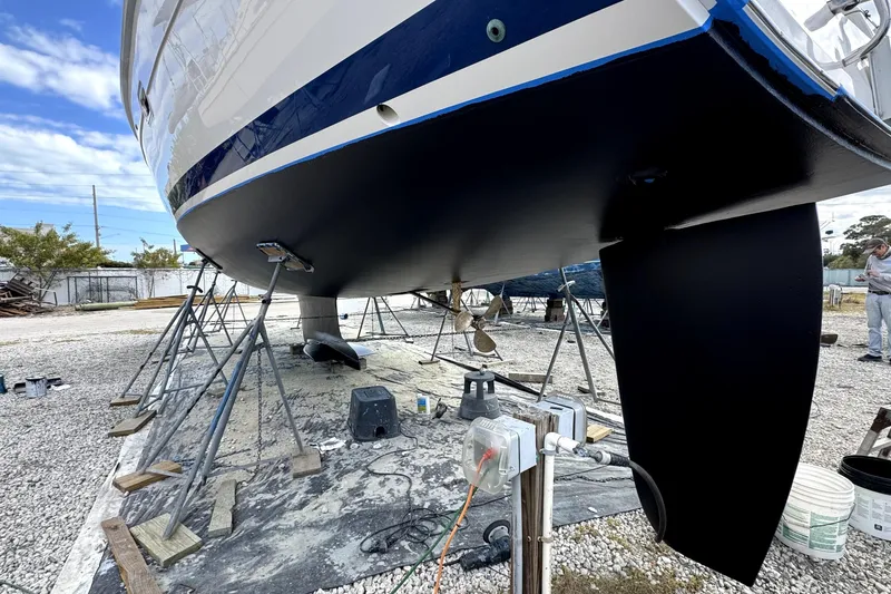 Slide: The Image of 2003 Hunter 426 Deck Salon sailboat on stands, undergoing maintenance in a boatyard. - 96