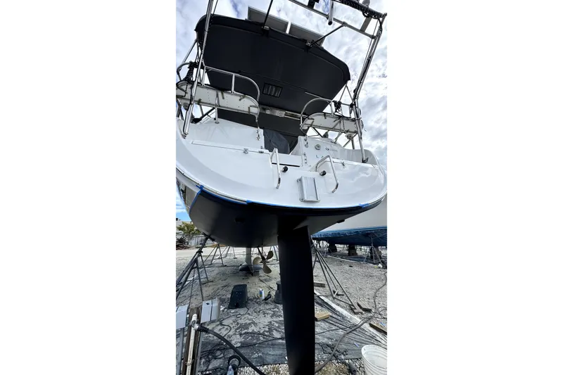 Slide: The Image of 2003 Hunter 426 Deck Salon sailboat on dry dock, viewed from the stern. - 98