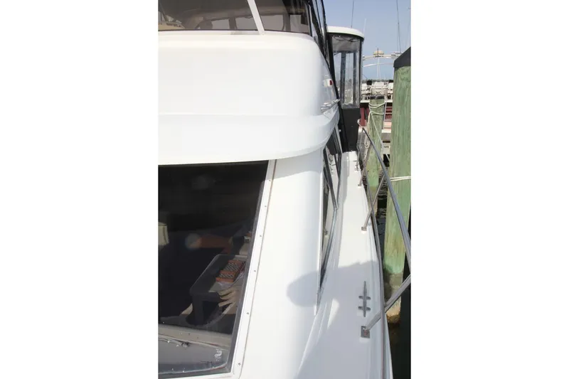 Slide: The Image of 1997 Cruisers Yachts 3650 Motoryacht docked, side view with railing and windows. - 11