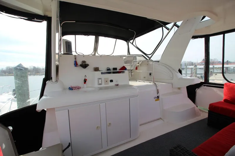 Slide: The Image of 1997 Cruisers Yachts 3650 Motoryacht interior with seating and helm station, docked at marina. - 12