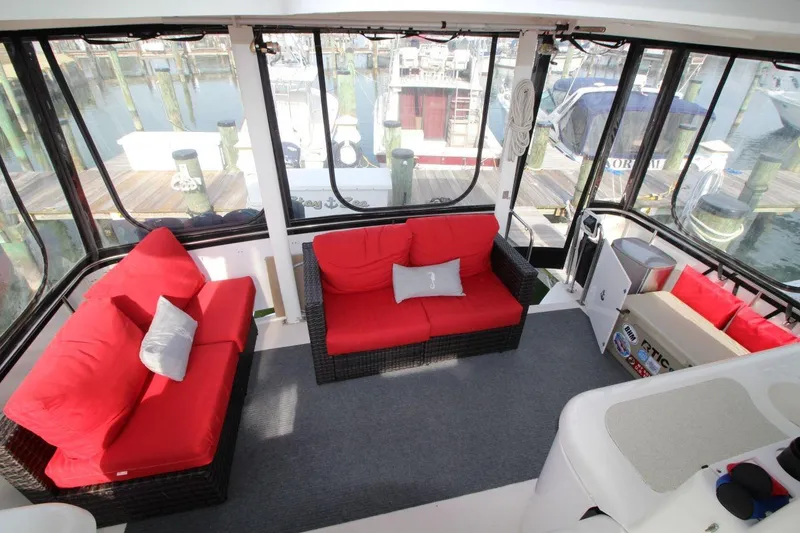 Slide: The Image of 1997 Cruisers Yachts 3650 Motoryacht interior with red cushioned seating and marina view. - 13