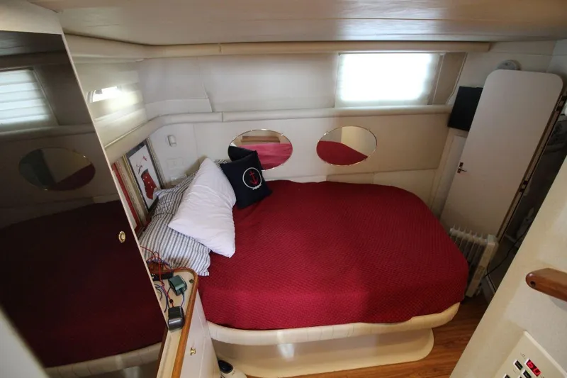 Slide: The Image of 1997 Cruisers Yachts 3650 Motoryacht bedroom with red bedding and modern decor. - 25