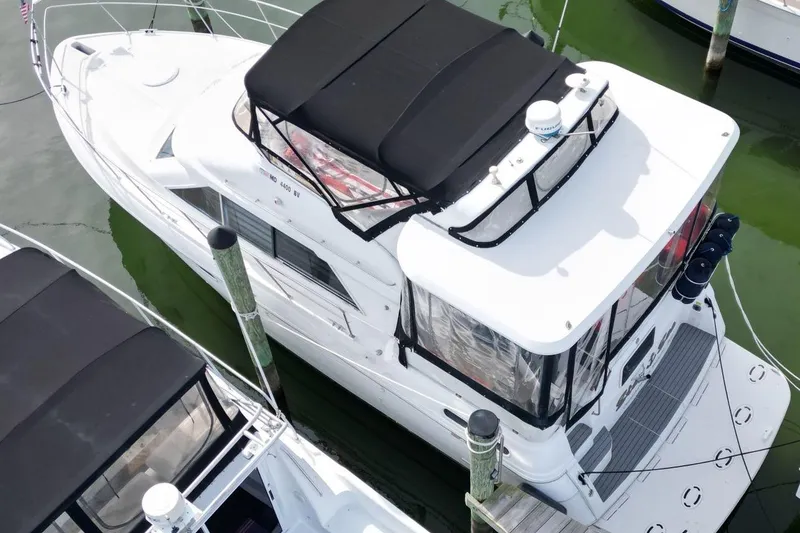 Slide: The Image of 1997 Cruisers Yachts 3650 Motoryacht docked, aerial view, white exterior, black canopy. - 3