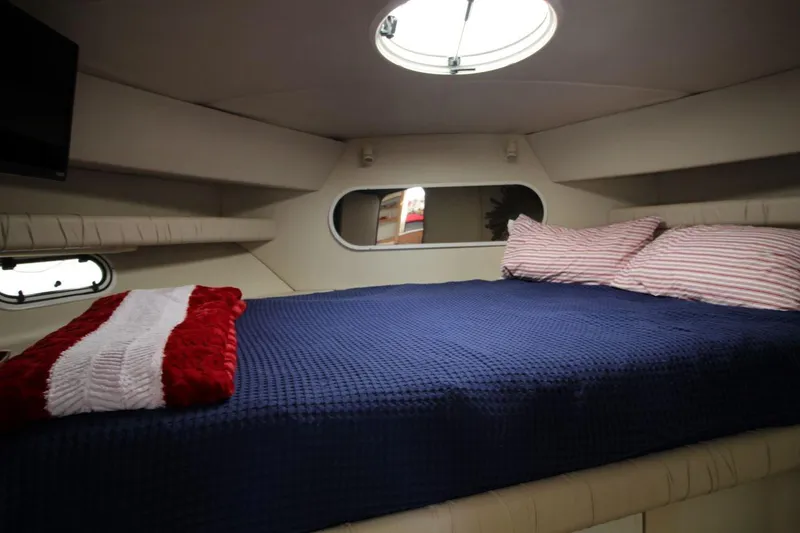 Slide: The Image of Cozy cabin interior of 1997 Cruisers Yachts 3650 Motoryacht with blue bedding and porthole. - 30