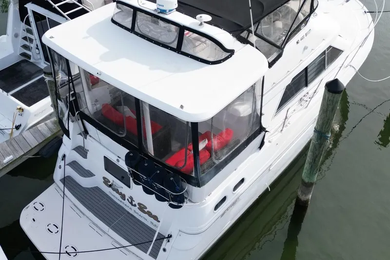 Slide: The Image of 1997 Cruisers Yachts 3650 Motoryacht docked, featuring spacious deck and enclosed cabin. - 7