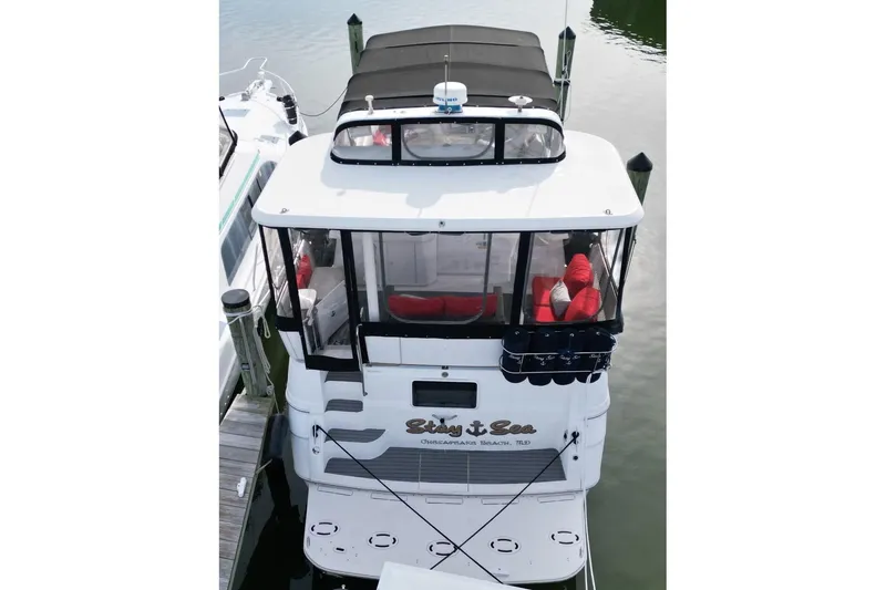 Slide: The Image of 1997 Cruisers Yachts 3650 Motoryacht docked, featuring a spacious deck and black canopy. - 8