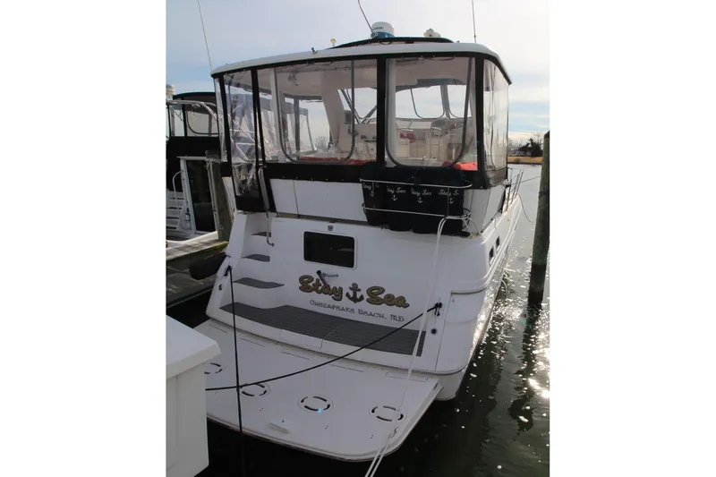 Slide: The Image of 1997 Cruisers Yachts 3650 Motoryacht docked, rear view with enclosed deck. - 1