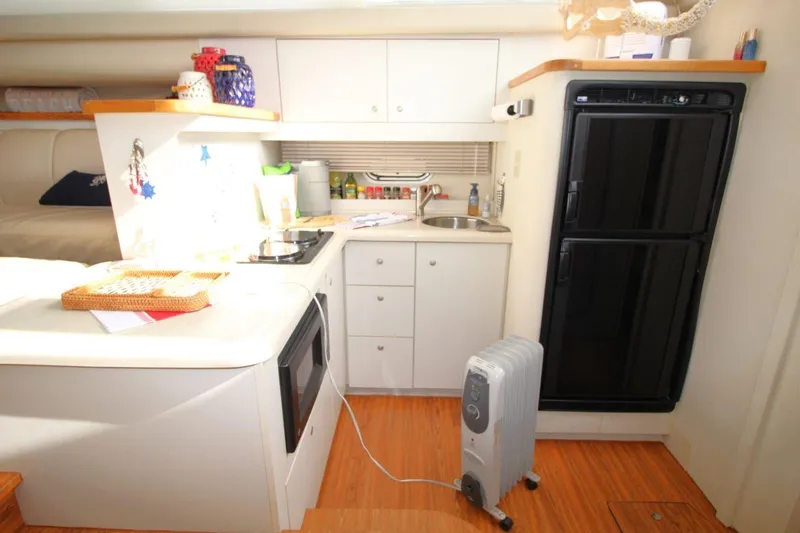 Slide: The Image of 1997 Cruisers Yachts 3650 Motoryacht interior kitchen with appliances and wooden flooring. - 24