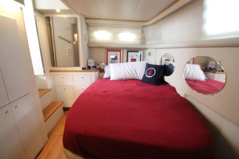 Slide: The Image of 1997 Cruisers Yachts 3650 Motoryacht cabin with red bedding and nautical decor. - 27