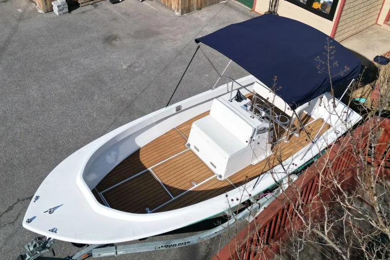 Slide: The Image of 1979 Shamrock 200 Stalker boat with wooden deck and blue canopy, parked on trailer. - 4