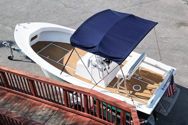 Slide: The Image of 1979 Shamrock 200 Stalker boat with blue canopy and wooden deck, viewed from above. - 5