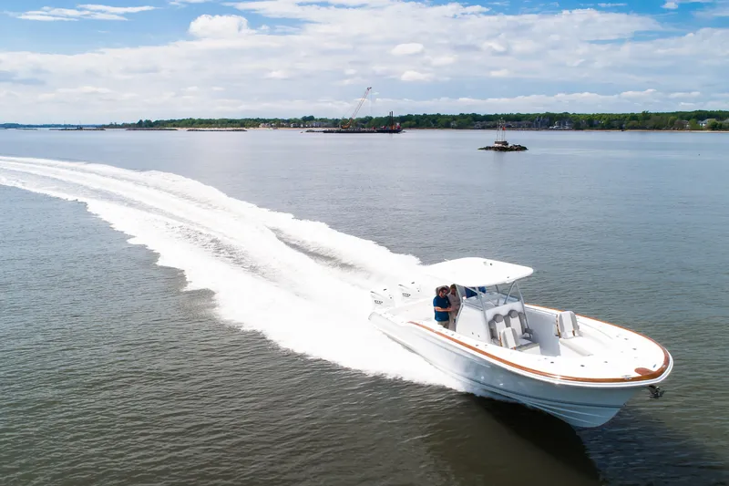Slide: The Image of 2019 Buddy Davis 34 Center Console cruising on open water, creating a dynamic wake. - 7