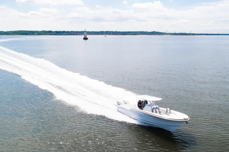 Slide: The Image of 2019 Buddy Davis 34 Center Console boat cruising on open water, leaving a wake. - 9