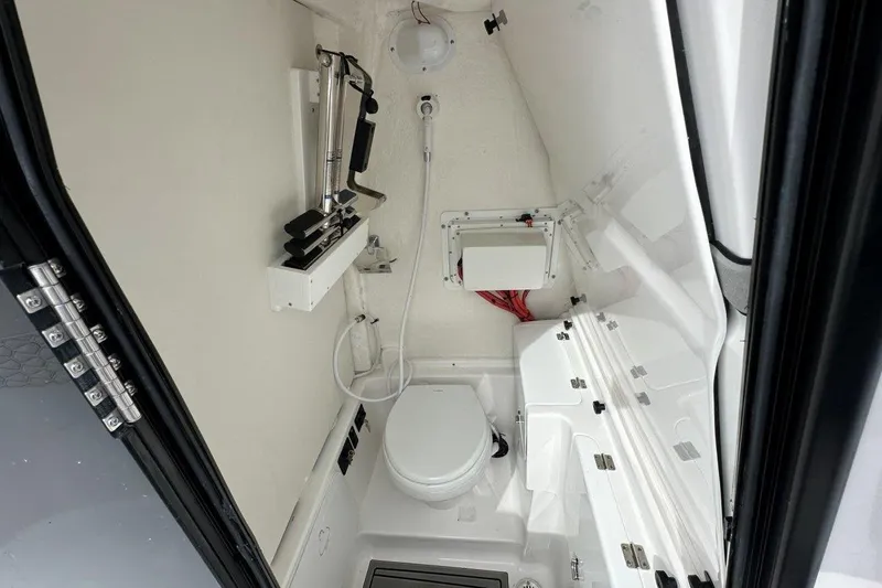 Slide: The Image of 2026 Tidewater 272 LXF boat interior with compact marine toilet and storage. - 13