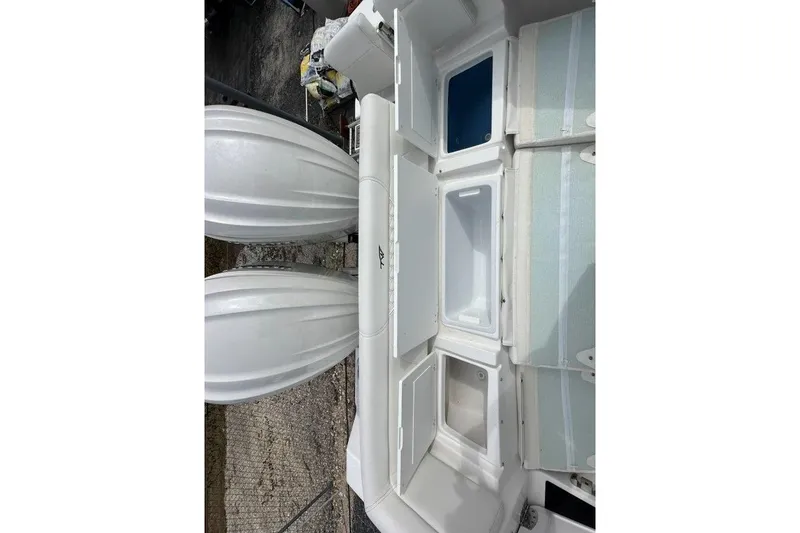 Slide: The Image of 2026 Tidewater 272 LXF boat interior with storage compartments and twin engines. - 17
