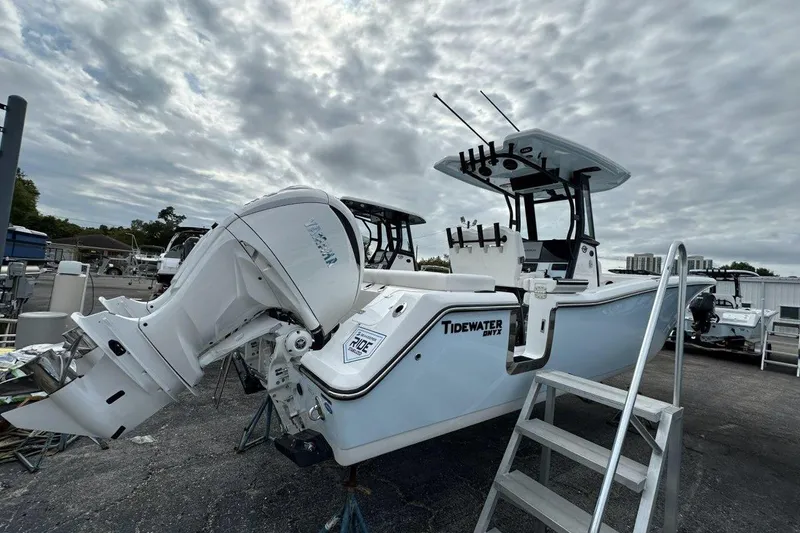 Slide: The Image of 2026 Tidewater 272 LXF boat with powerful outboard motor, docked under cloudy skies. - 2