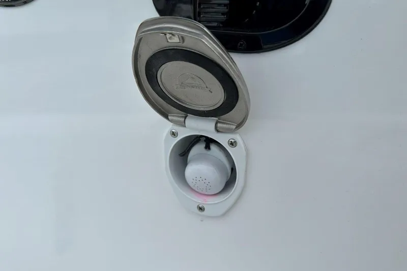 Slide: The Image of Open hatch on 2026 Tidewater 272 LXF boat, showing a small device inside. - 28