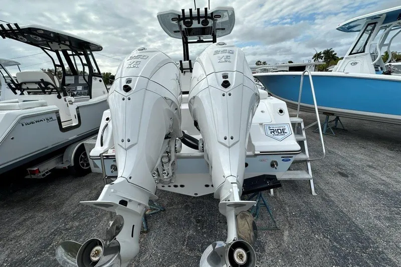 Slide: The Image of 2026 Tidewater 272 LXF boat with dual outboard engines, parked on a trailer. - 3