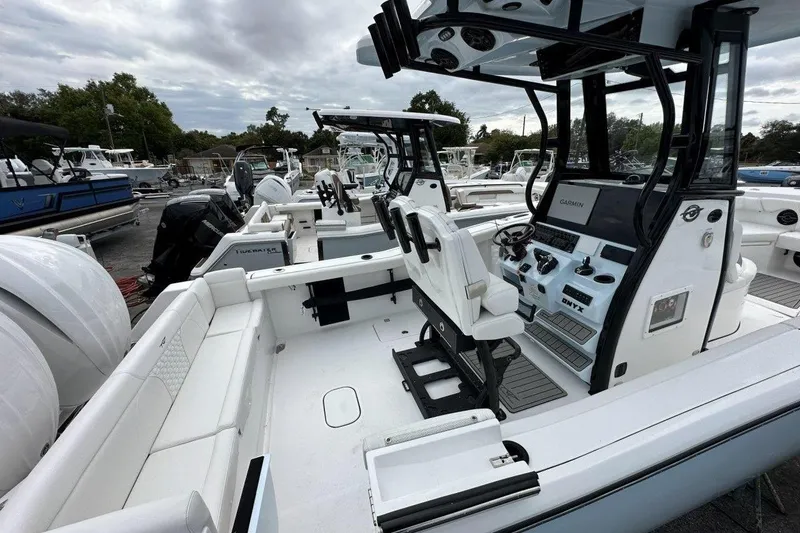 Slide: The Image of 2026 Tidewater 272 LXF boat interior with modern helm and seating, docked under cloudy skies. - 6