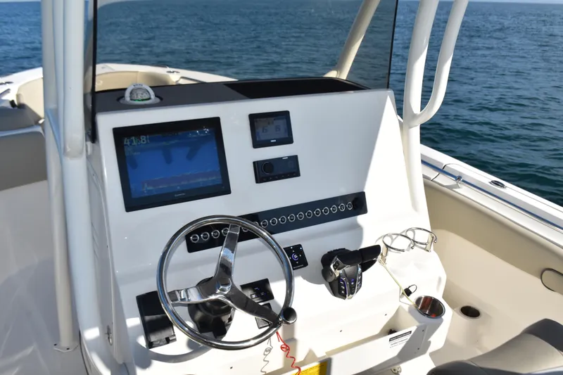Slide: The Image of 2024 Key West 263 FS boat dashboard with steering wheel and navigation screens. - 15