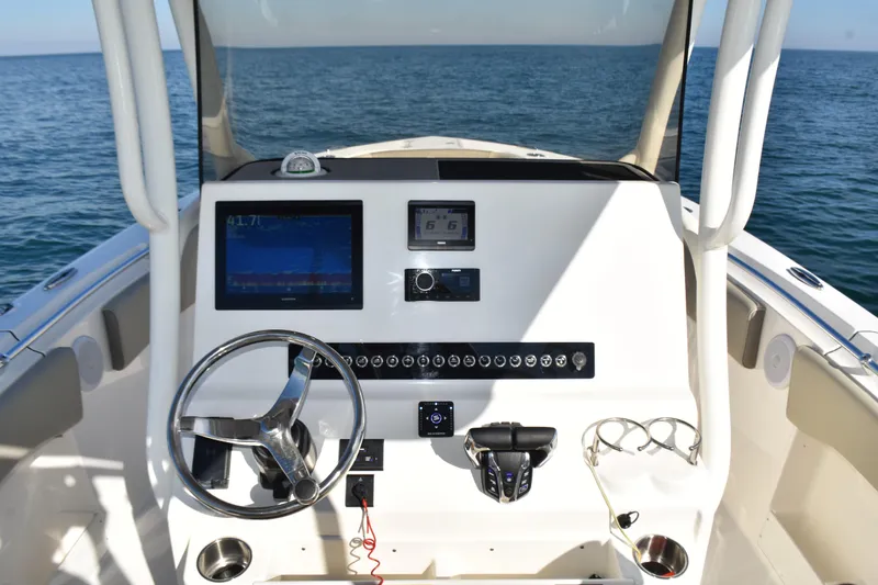 Slide: The Image of 2024 Key West 263 FS boat dashboard with steering wheel and navigation screens. - 16