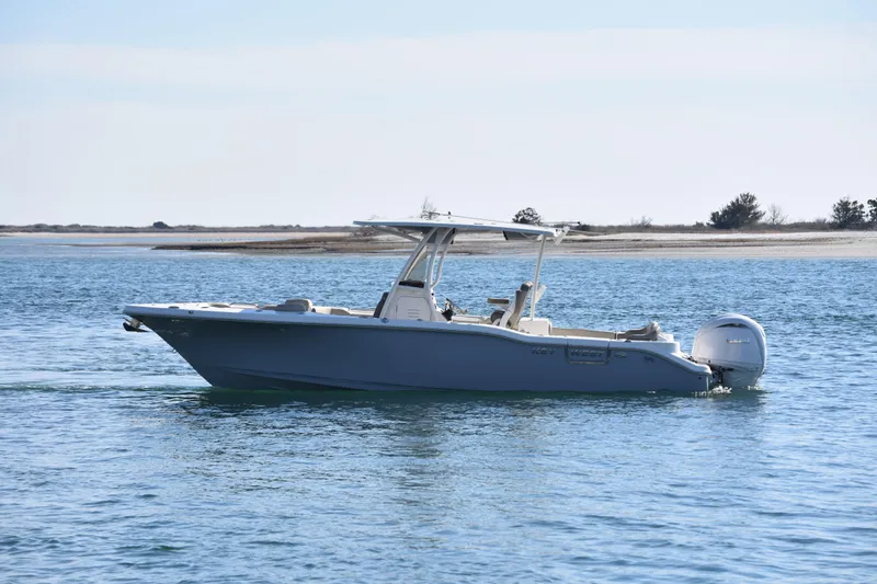Slide: The Image of 2024 Key West 263 FS boat cruising on calm waters near a sandy shoreline. - 2