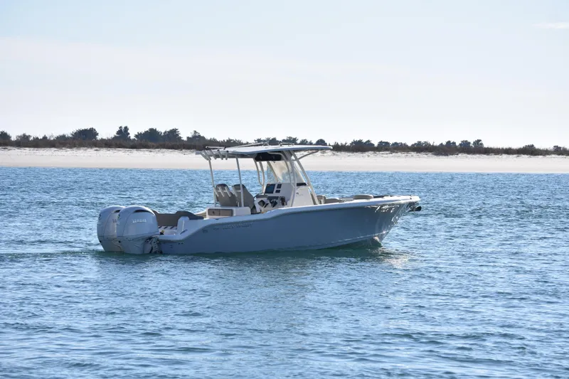 Slide: The Image of 2024 Key West 263 FS boat cruising on calm blue waters near a sandy shoreline. - 3