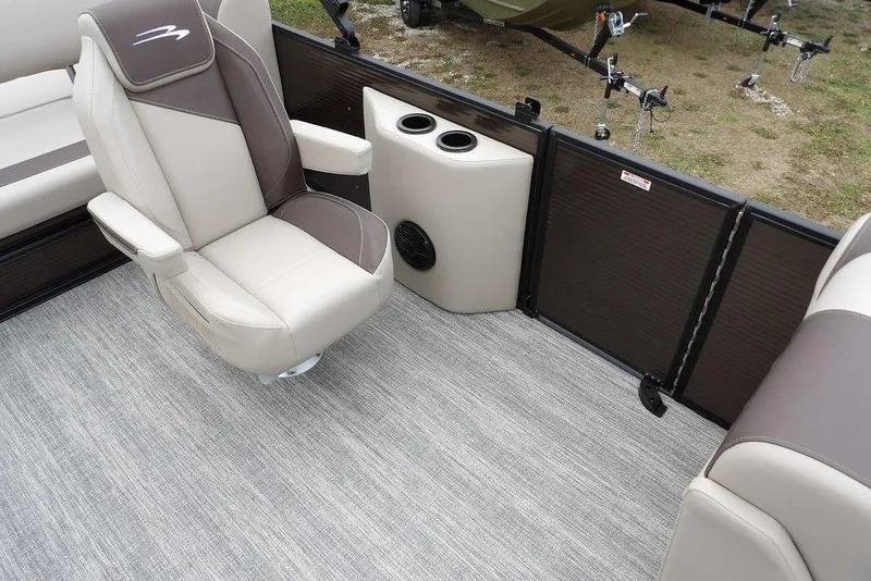 Slide: The Image of 2026 Bennington S Swingback 21 SSB interior with beige and brown seating, cup holders, and speaker. - 18