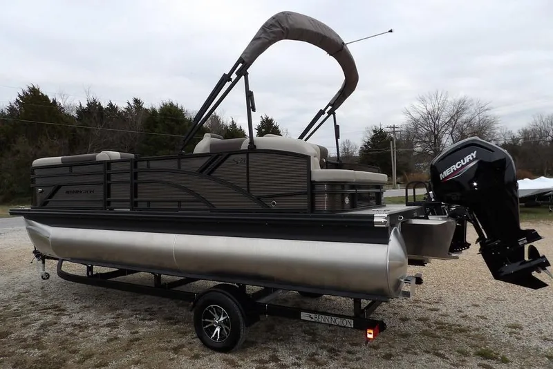 Slide: The Image of 2026 Bennington S Swingback 21 SSB pontoon boat with Mercury outboard motor on trailer. - 6