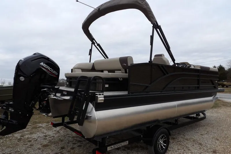 Slide: The Image of 2026 Bennington S Swingback 21 SSB pontoon boat with Mercury outboard engine on trailer. - 8